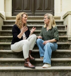 Maren Ulbrich und Stephanie Stobwasser von Matchmeister unterhalten sich auf Treppe.